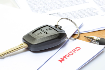 An auto financing application with a car key sitting on it